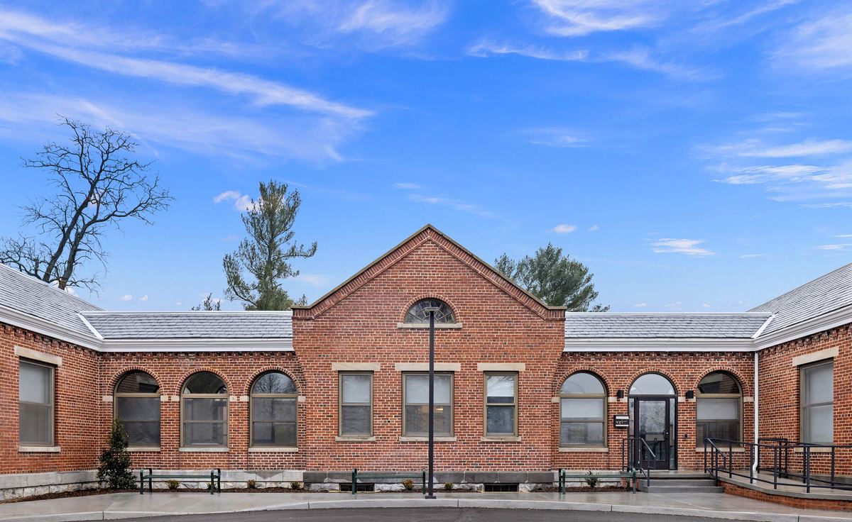 The restored brick campus from the drive, arched windows and slate roof