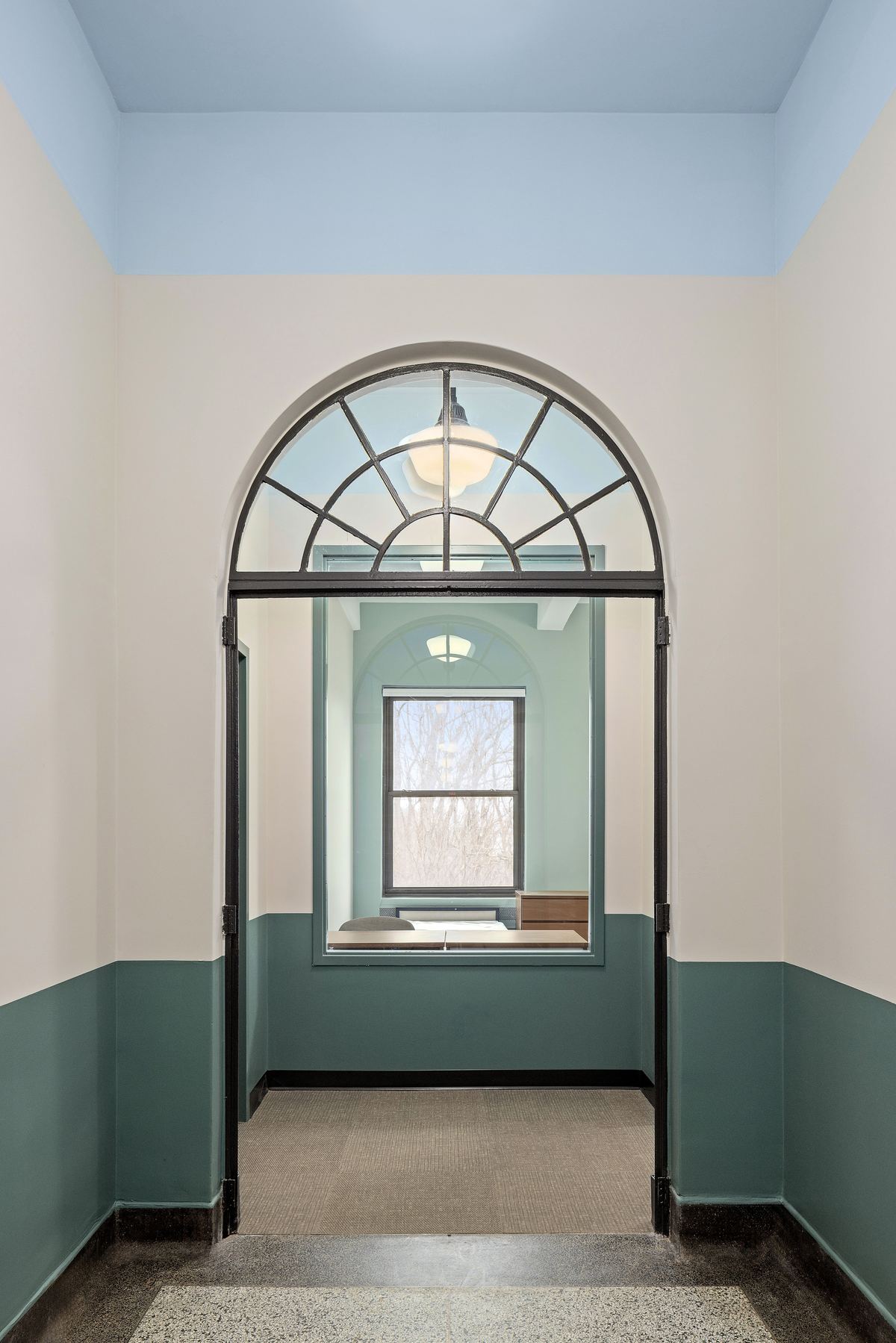 Arched entry vestibule with fanlight window and teal painted wainscot