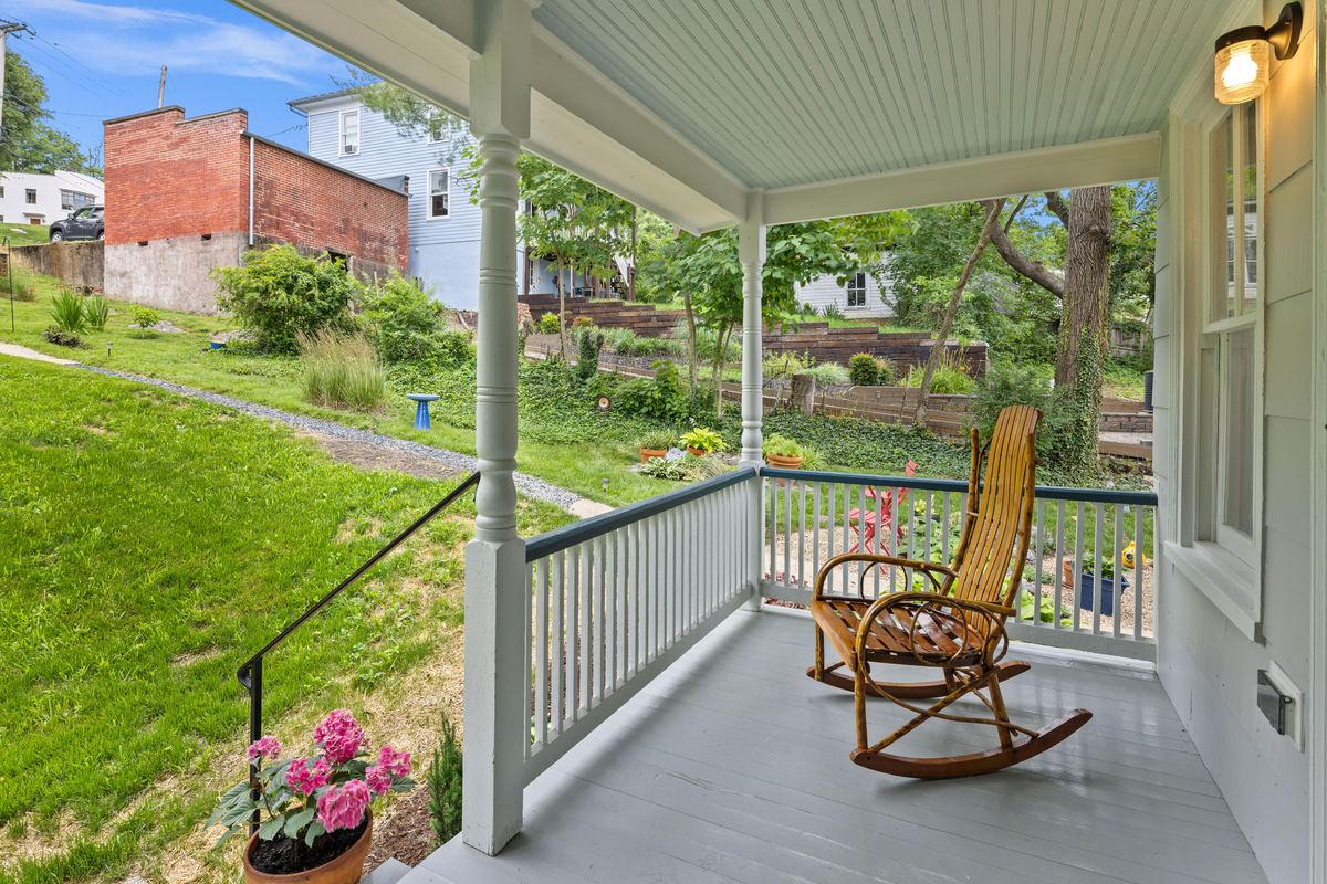 Covered rear porch with a rocking chair looking over a Staunton back yard