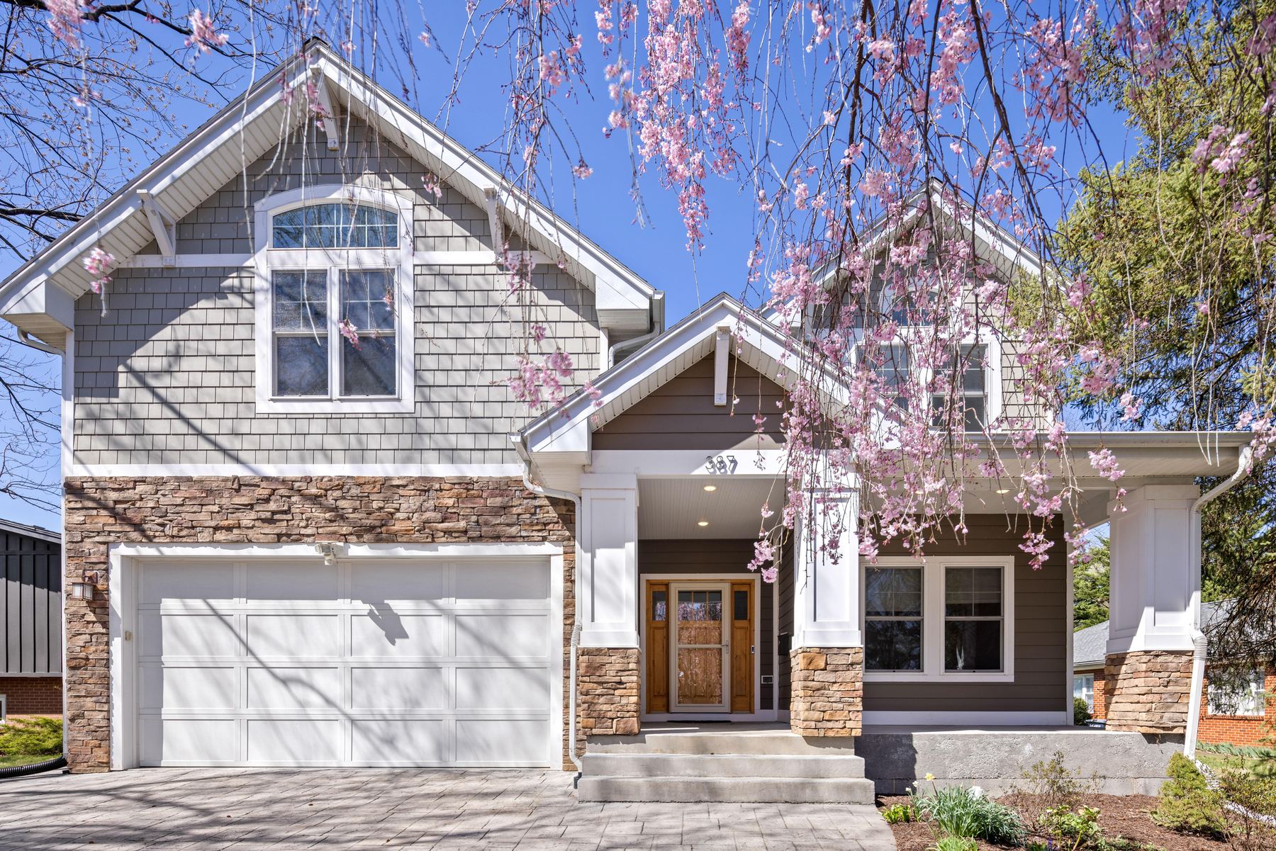 Craftsman home with stone piers under a weeping cherry in bloom, Harrisonburg