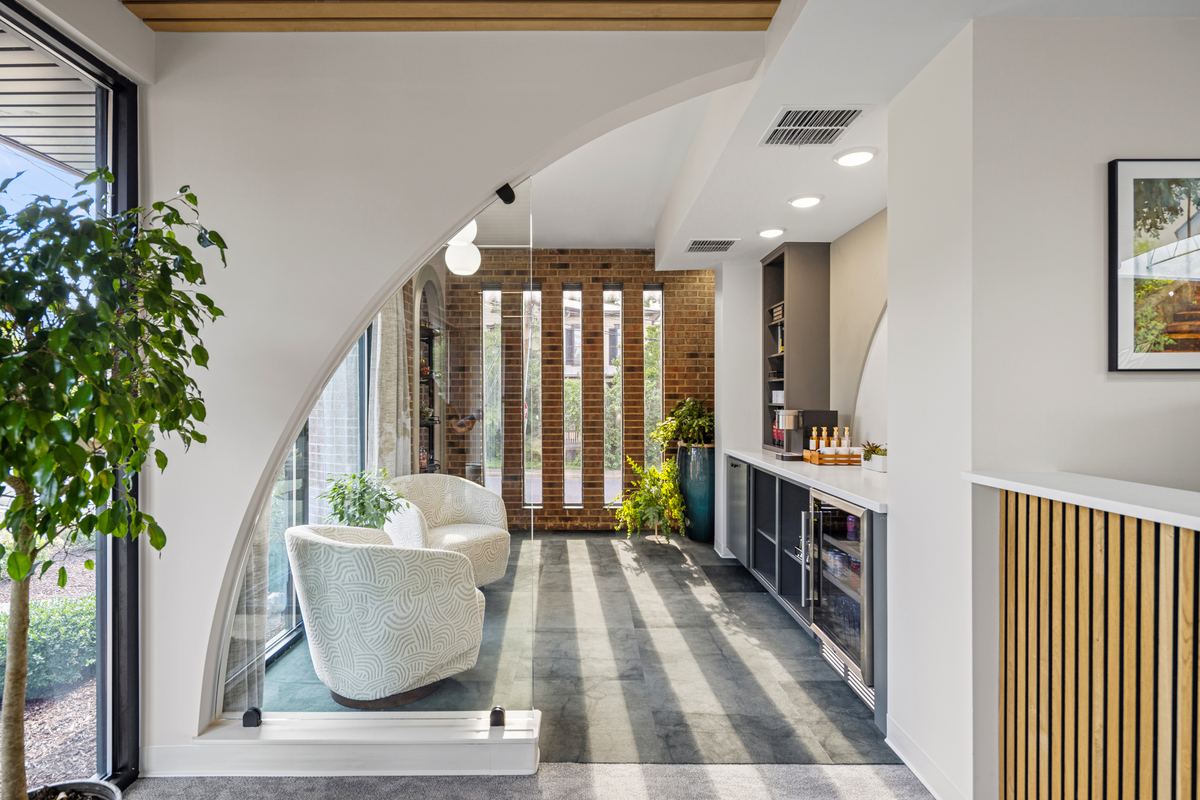 Arched waiting nook with a marble table and a wall of vertical fins