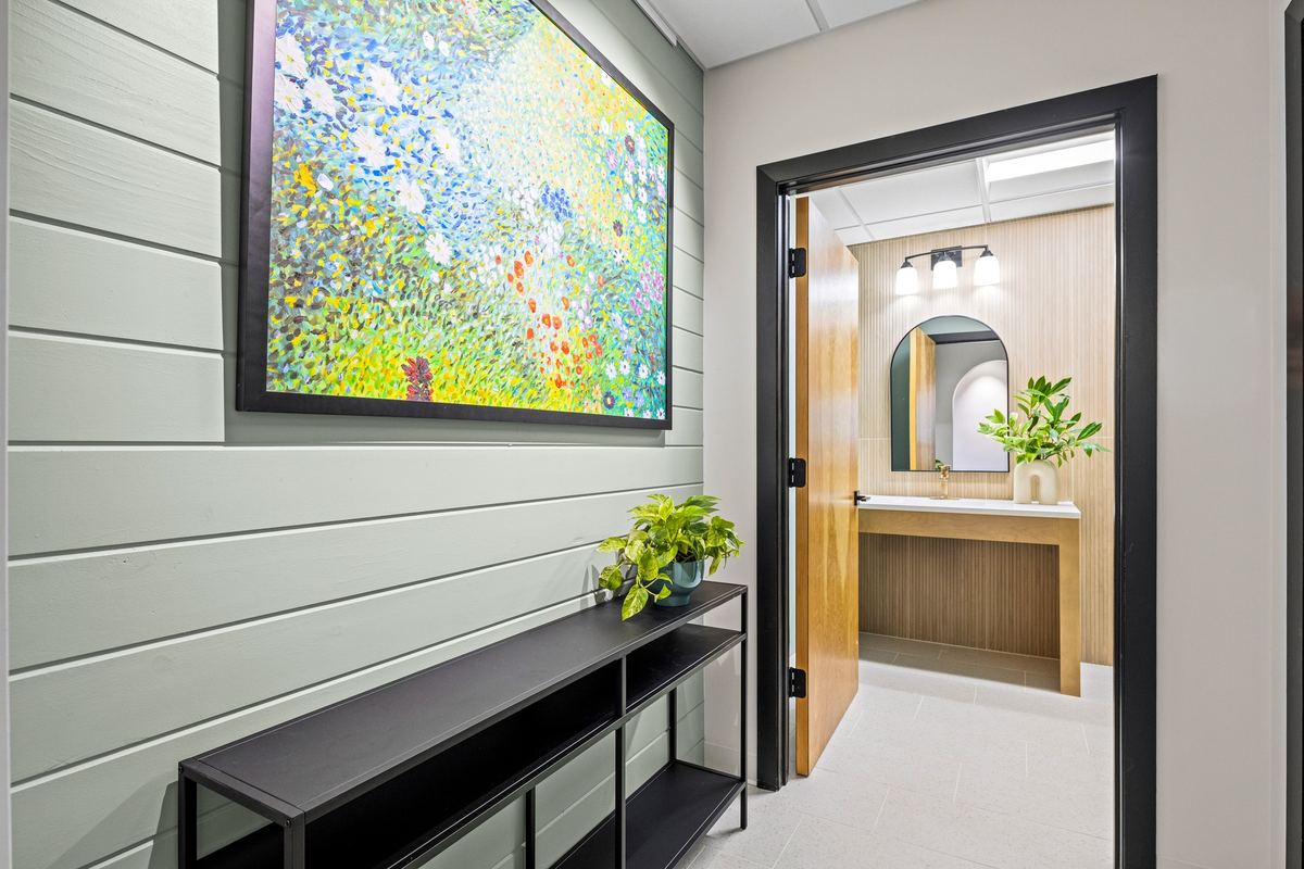 Hallway with a large meadow painting and oak doors