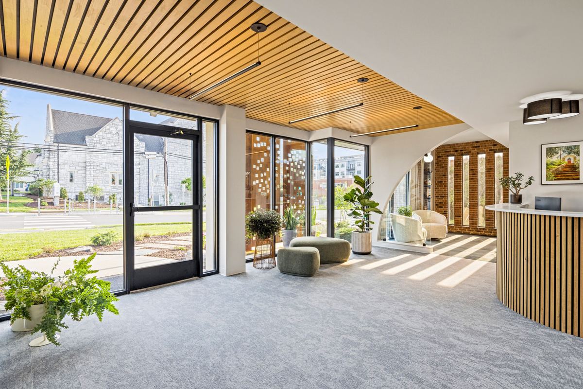 Reception in afternoon sun, slatted ceiling and a glass entry