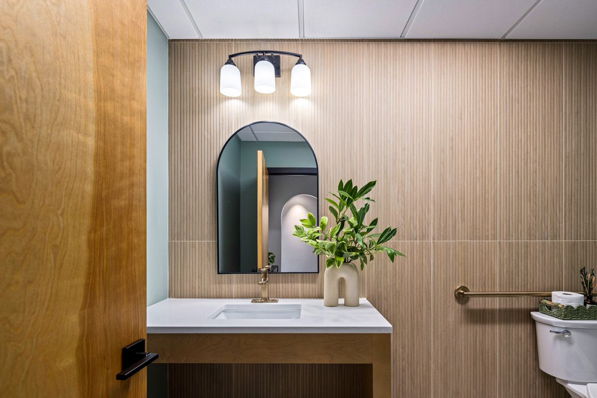 Arched mirror over an oak vanity
