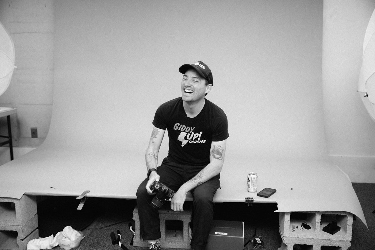 Nick Waite laughing on a studio set, camera in hand