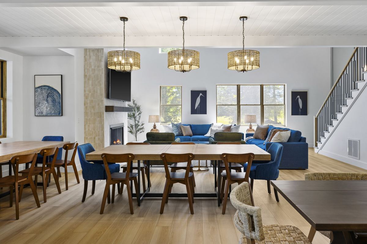 Dining room with a long table, blue chairs and three pendant lights