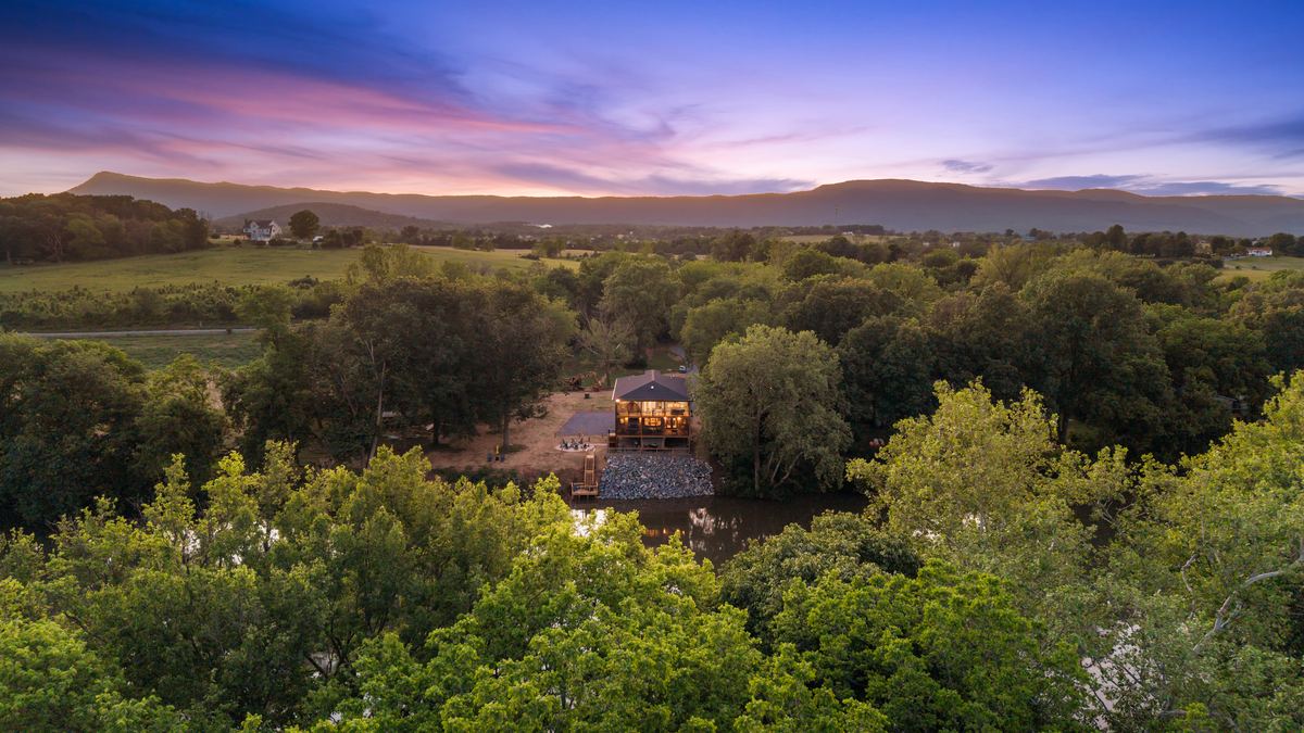 A river house lit at dusk below the Massanutten ridge, from the air