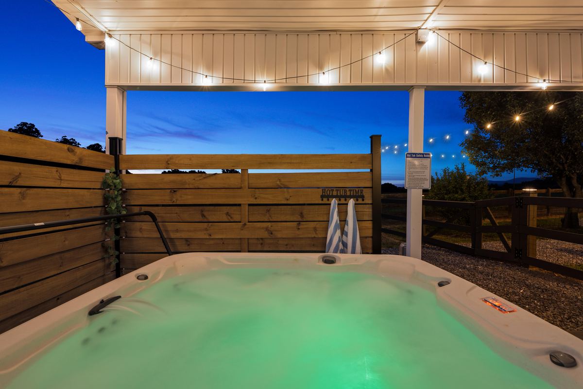 Hot tub under string lights at dusk