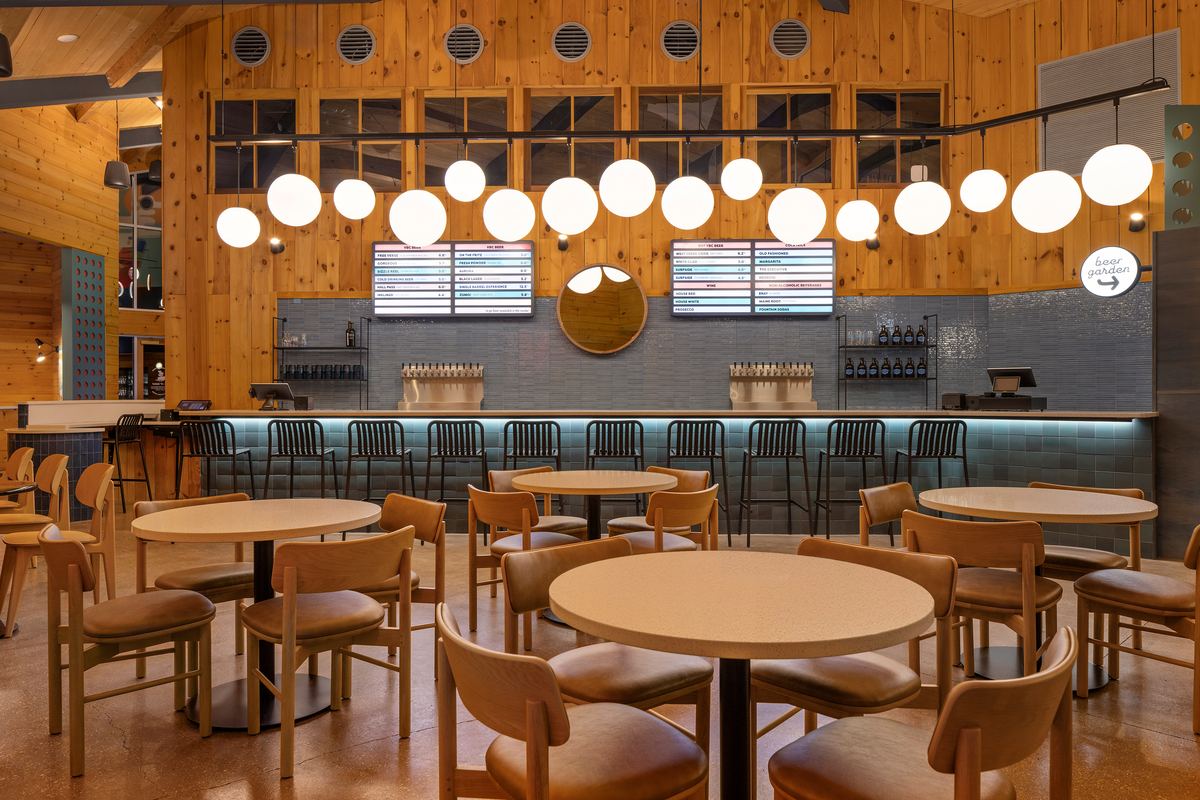 Taproom bar under a row of globe pendants and a vaulted pine ceiling, Virginia Beer Co