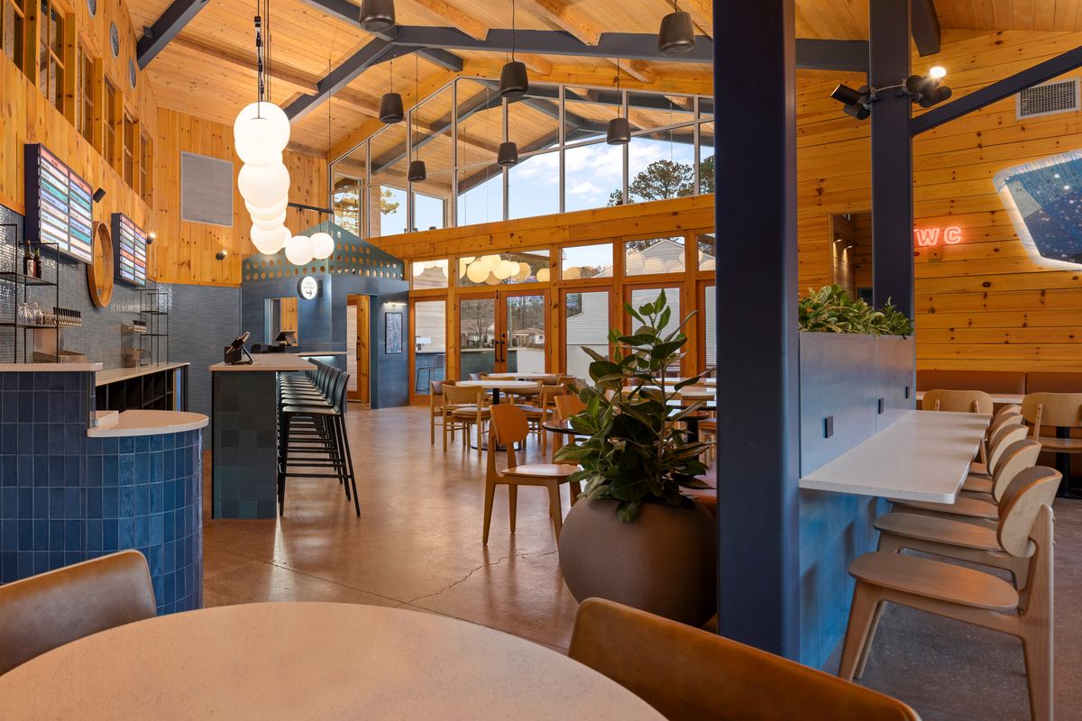 Corner of the taproom with blue tile, timber trusses and pendant lights