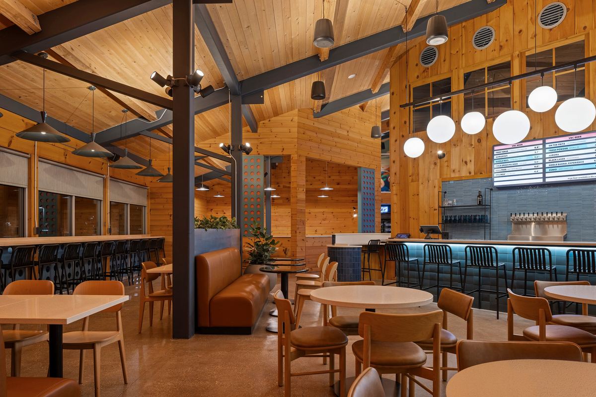 Taproom tables under globe pendants and timber trusses