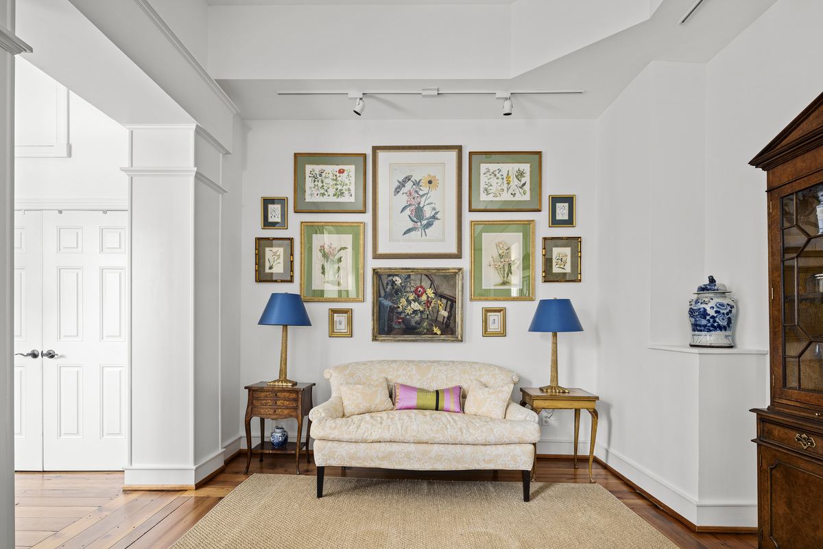Sitting room with a gallery wall of botanical prints and a settee